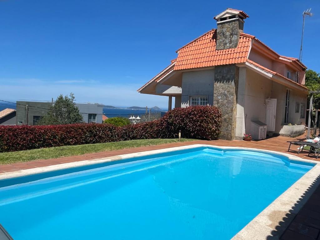 a large swimming pool in front of a house at Casa con piscina, vistas y cerca de las playas in Vigo