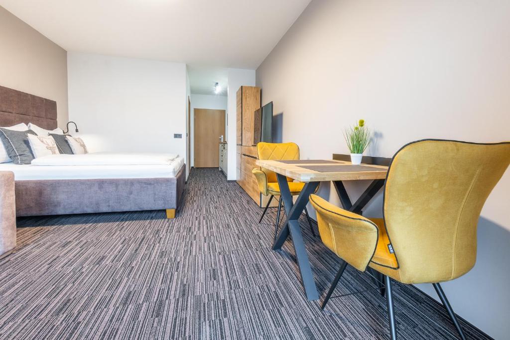 A bed or beds in a room at Praga Apartments & Restaurant Zell am See-Kaprun