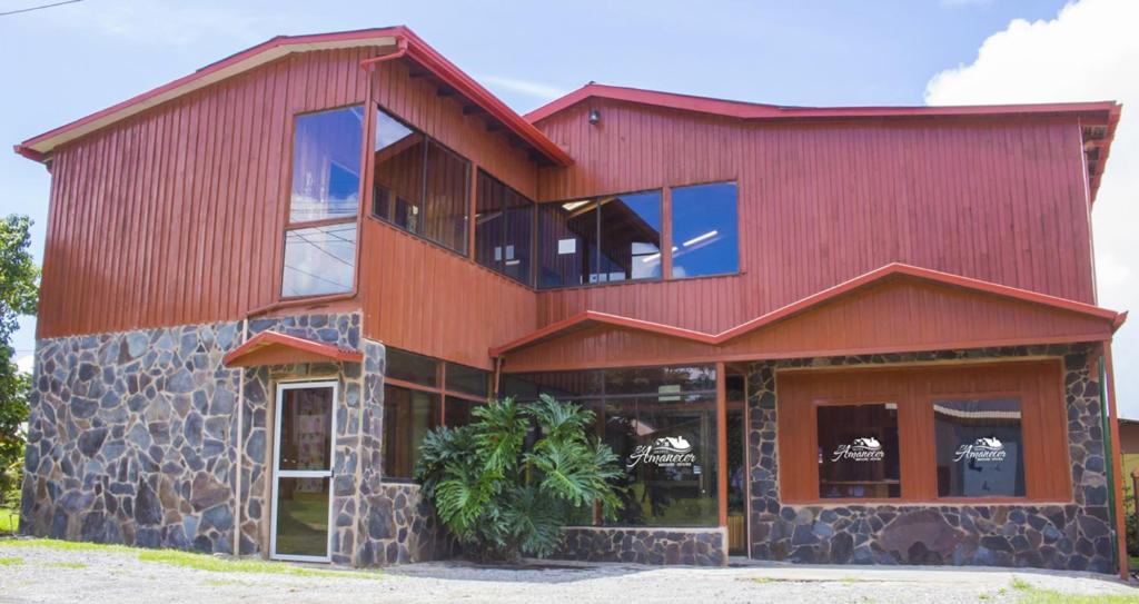 un edificio rojo con techo rojo y ventanas en Hotel El Amanecer, en Monteverde