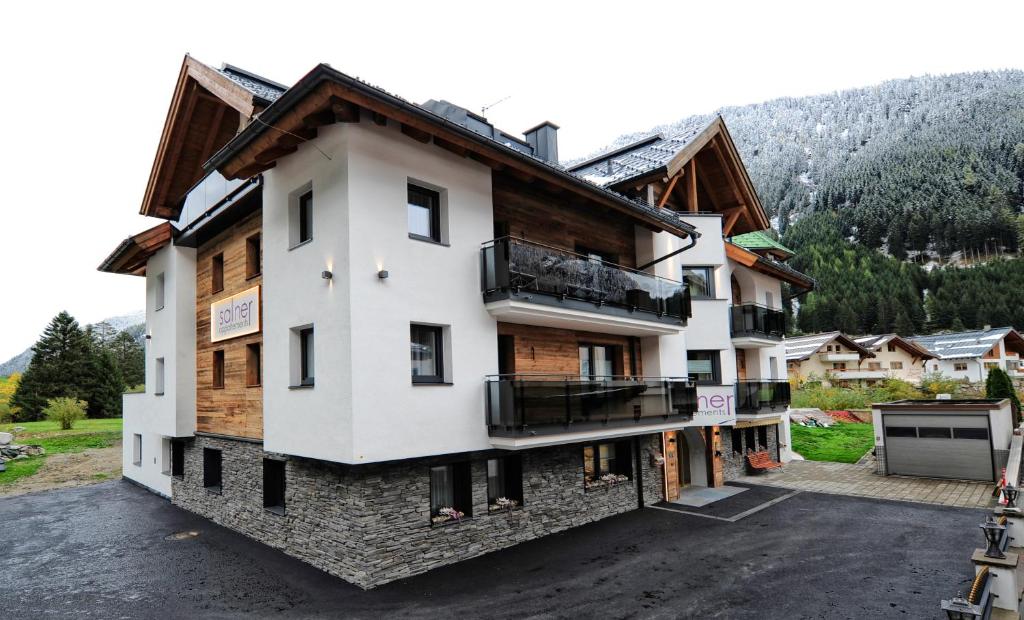 an apartment building with a balcony in the mountains at Apart Salner in Ischgl