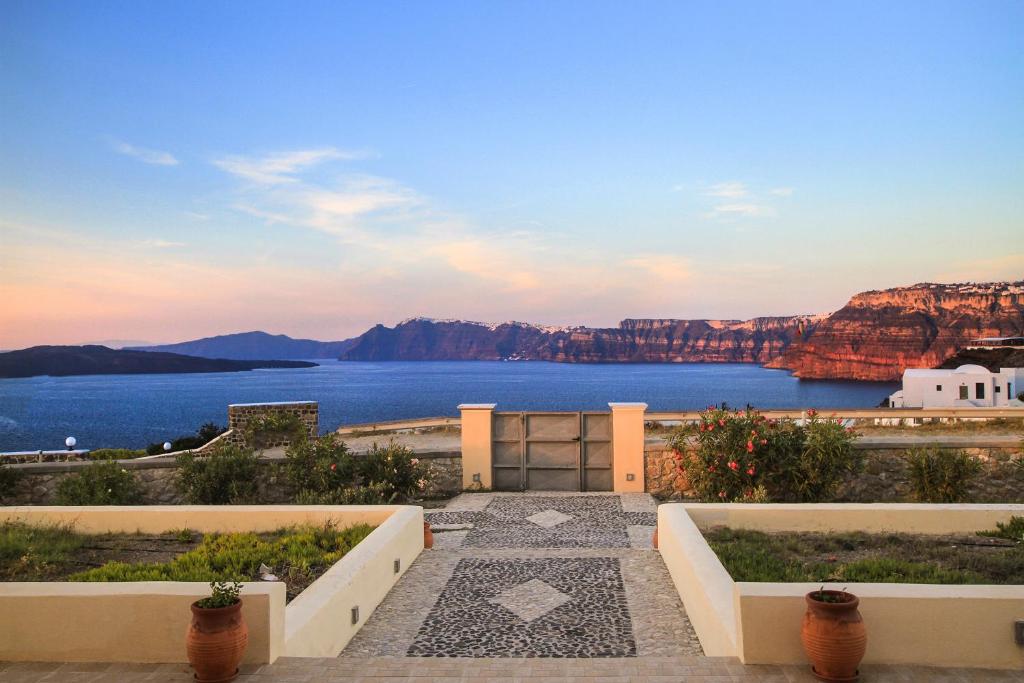 een uitzicht op het water en de bergen vanuit een gebouw bij Alba Caldera Villa in Akrotiri