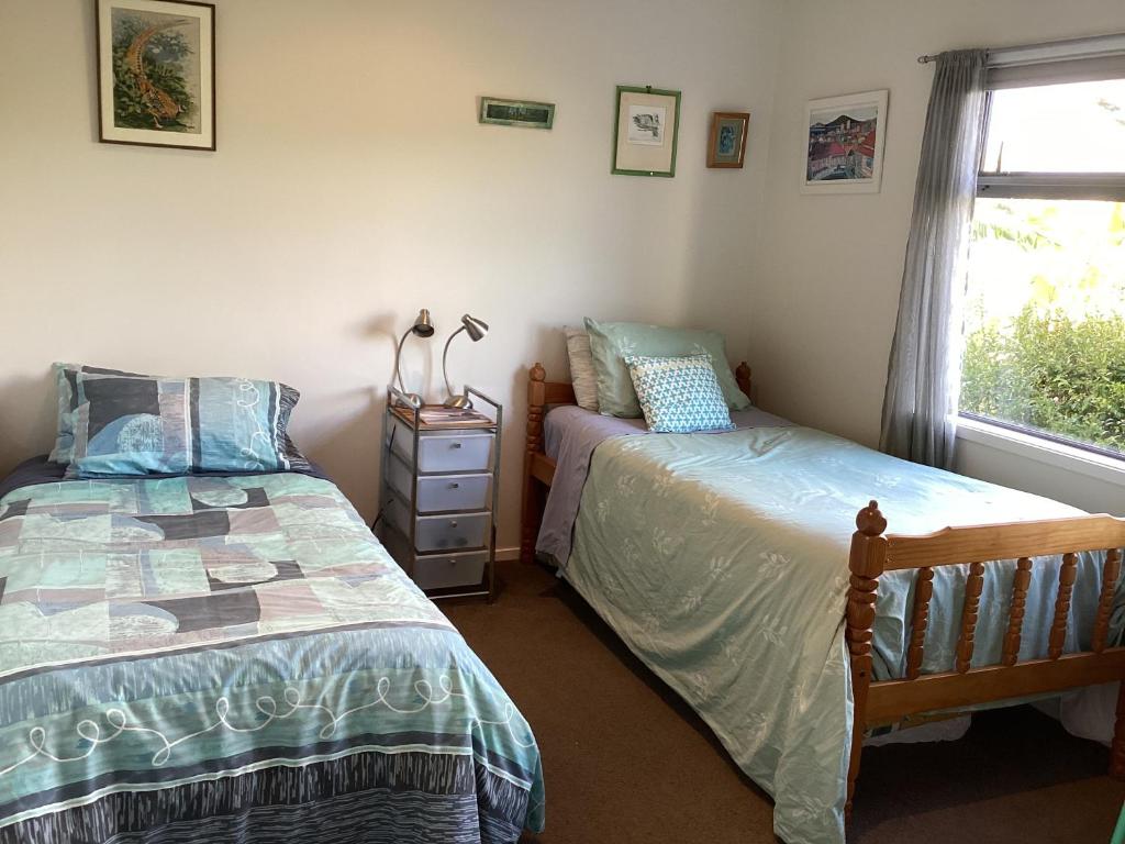 a bedroom with two twin beds and a window at Al Der Rocs B & B in Kerikeri