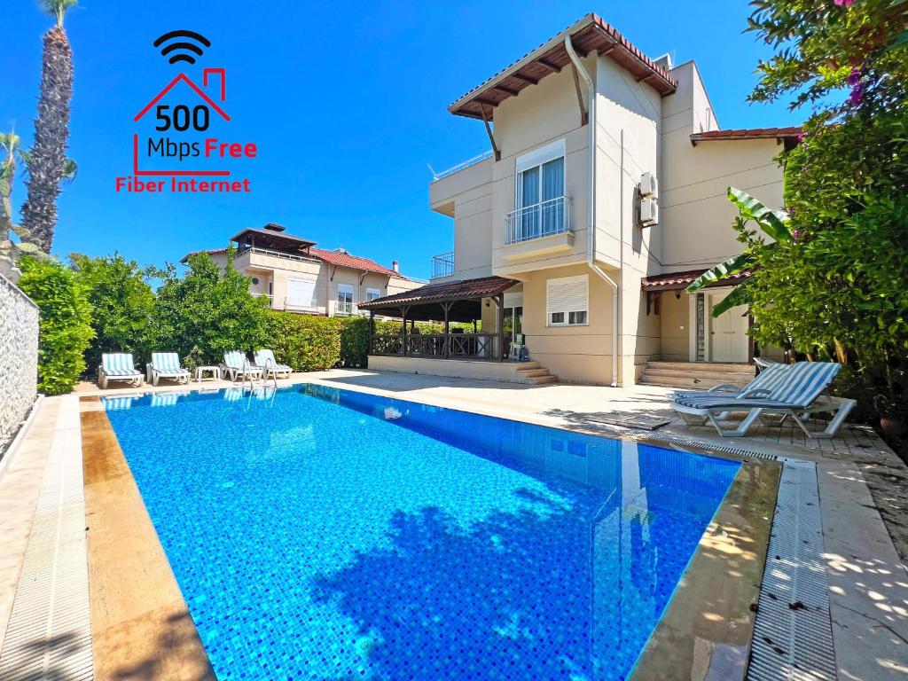 a villa with a swimming pool and a house at Paradise Town Villa Abel in Belek