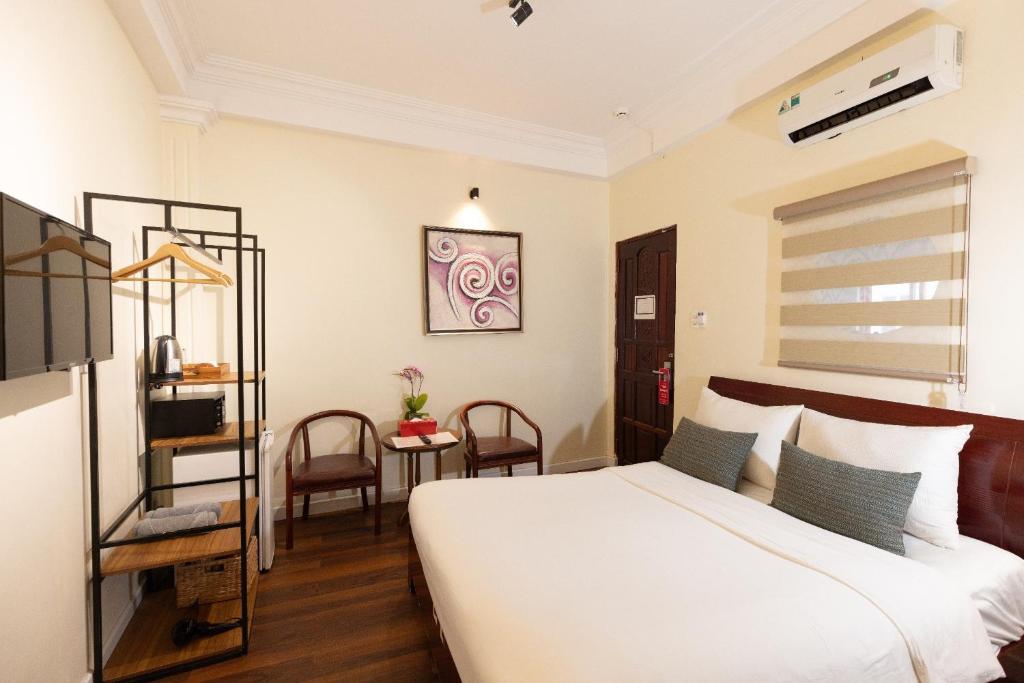 9 Hostel and Suites في مدينة هوشي منه: غرفة نوم بسرير وطاولة وكراسي