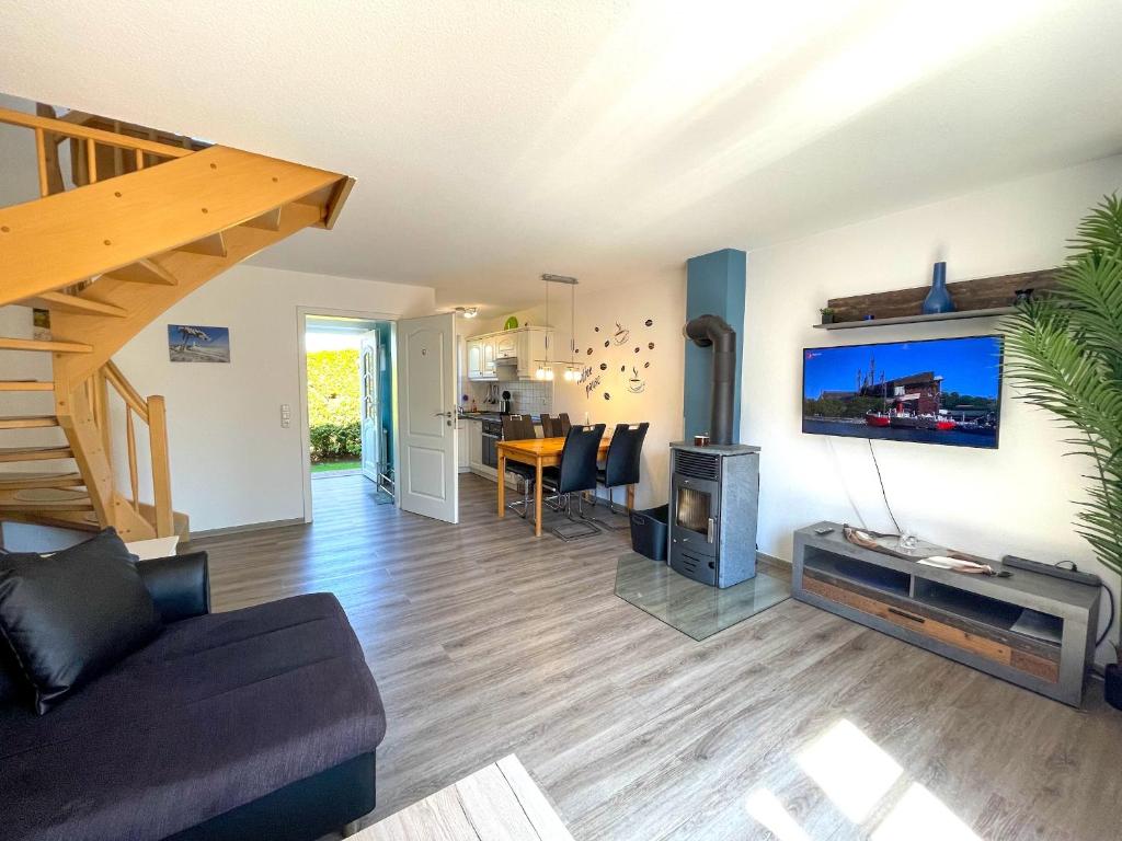 a living room with a couch and a flat screen tv at Seehund Feriendoppelhaus "Schäferhund" in Thiessow