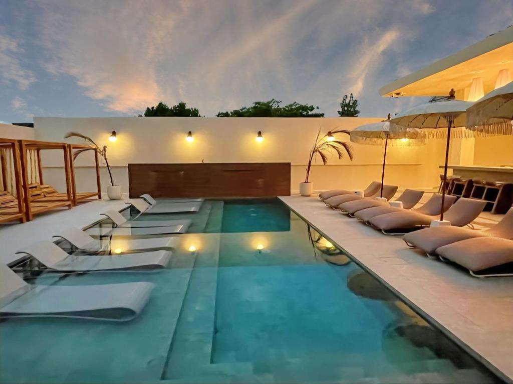 uma piscina com espreguiçadeiras e uma piscina em Bali Poshtel PR em San Juan