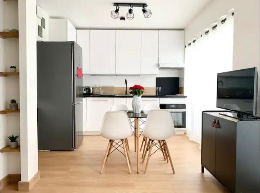 a kitchen with a table and two white chairs at Paris with AC near Eiffel Tower in Paris