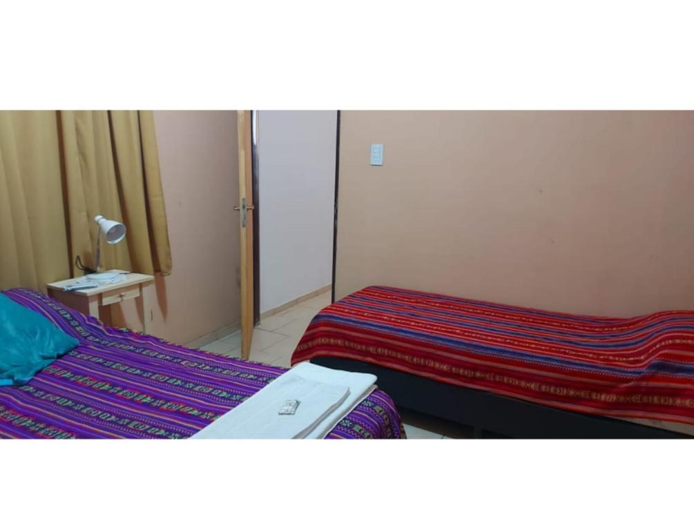 una habitación con dos camas y un espejo en Raíces Diaguitas II, en Vinchina