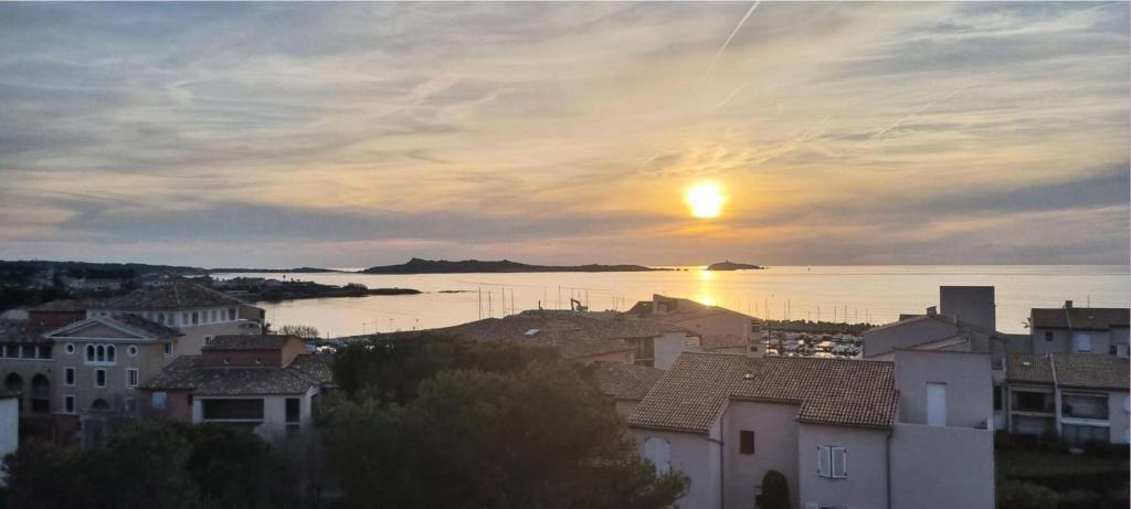 un coucher de soleil sur une ville avec des maisons et l'eau dans l'établissement Résidence Verdon - Magnifique T2, vue mer , à proximité des plages et des commerces MAE-6111, à Six-Fours-les-Plages