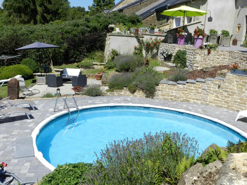 ein großer Pool in einem Hof mit einer Steinmauer in der Unterkunft O Sixième Sens in Williers