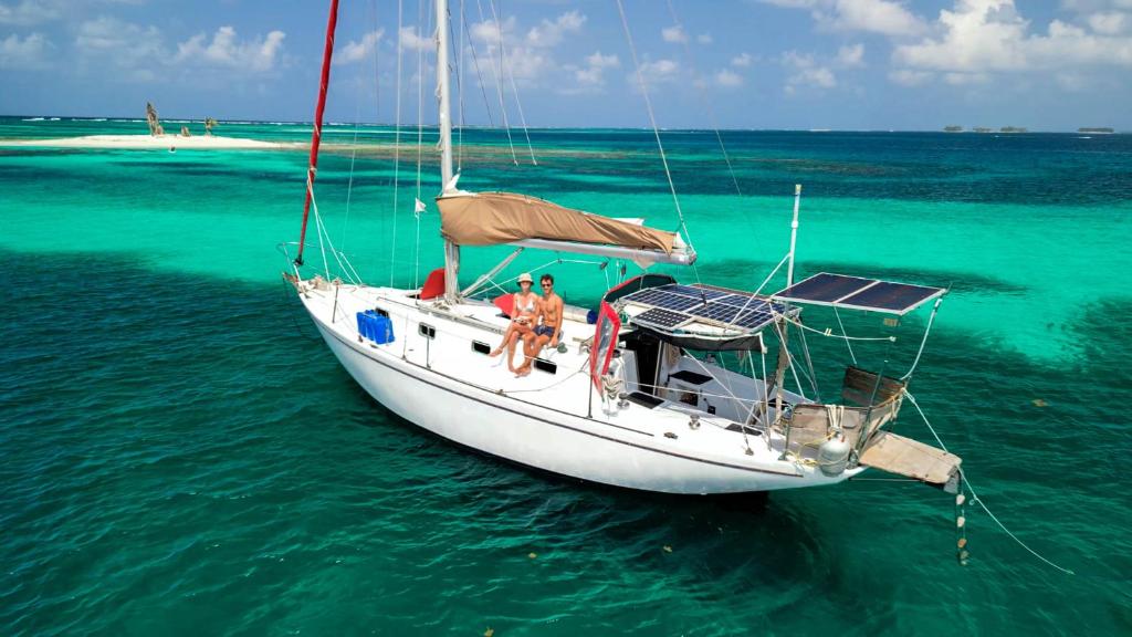 San Blas Sailing Experience With Us! في El Porvenir: شخصان على قارب شراعي في المحيط