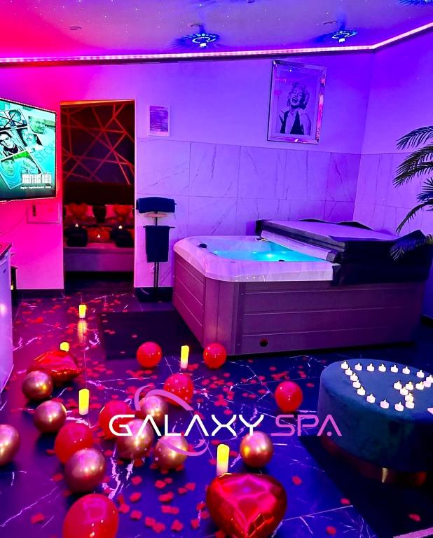 une chambre avec un lit, une télé et des ballons dans l'établissement GALAXY SPA - Suite Jupiter Jacuzzi Privatif, à Champigneulles