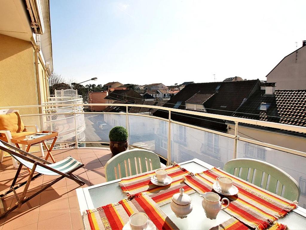 un homme assis à une table sur un balcon dans l'établissement Appartement Tout Confort entre Plage et Commerces à Saint-Brevin-les-Pins - FR-1-364-55, à Saint-Brévin-les-Pins