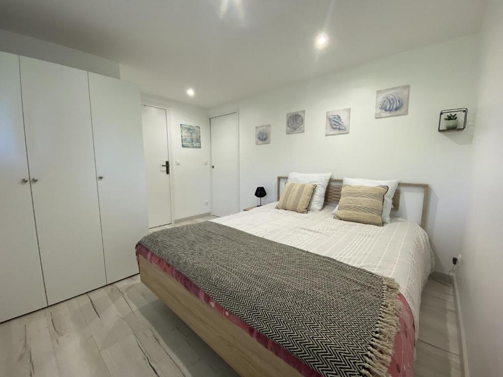 - une chambre avec un grand lit et des murs blancs dans l'établissement Rez-de-chaussée rénové avec jardin clos, à 1,6 km de la plage, idéal pour 2 adultes et 2 enfants - FR-1-364-142, à Saint-Brévin-les-Pins