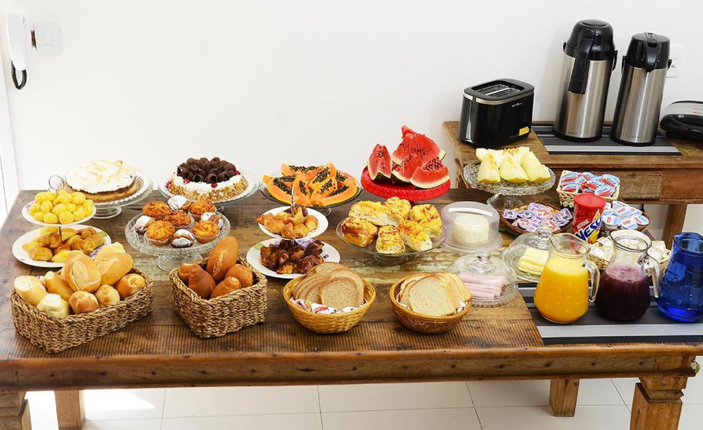 uma mesa com muitas cestas de comida em Pousada do Pascoal em Juqueí