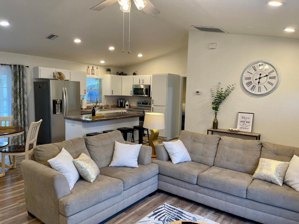 a living room with a couch and a clock on the wall at Cozy 3 Bedroom Vacation Home in North Port