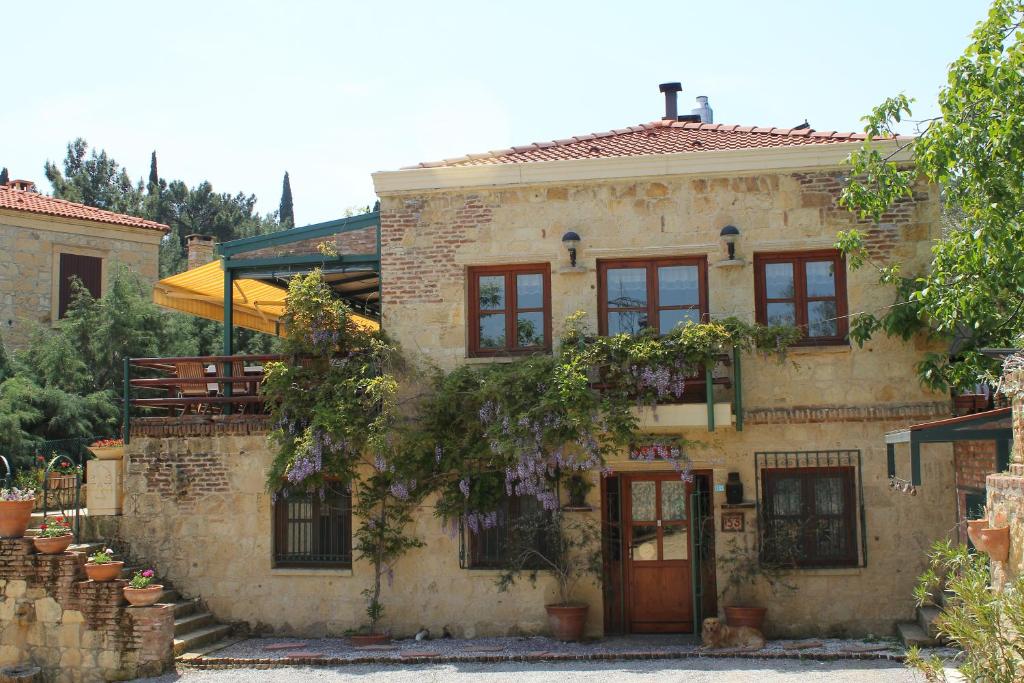 an old stone house with a tree in front of it at Kisik Konagi in Küçükkuyu