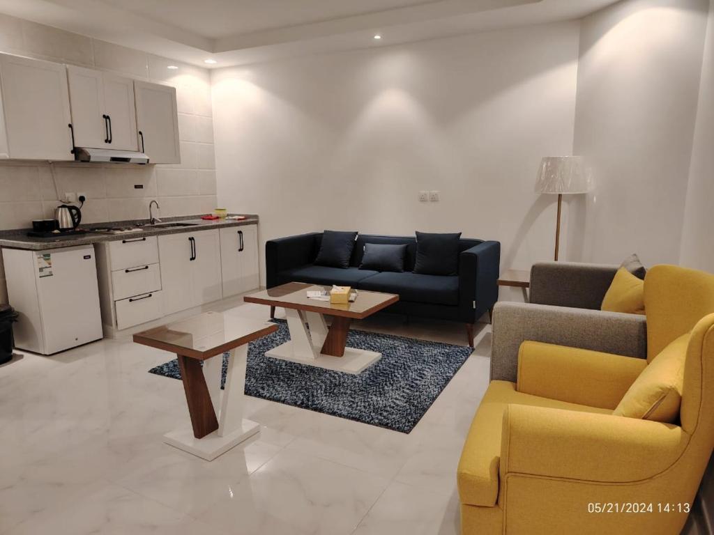 a living room with two couches and a table and a kitchen at شقق درة العريش لشقق المخدومة in Jazan