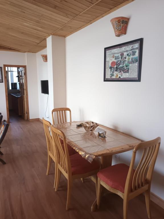 a dining room with a wooden table and chairs at Hill Billy Homes in Nāldera