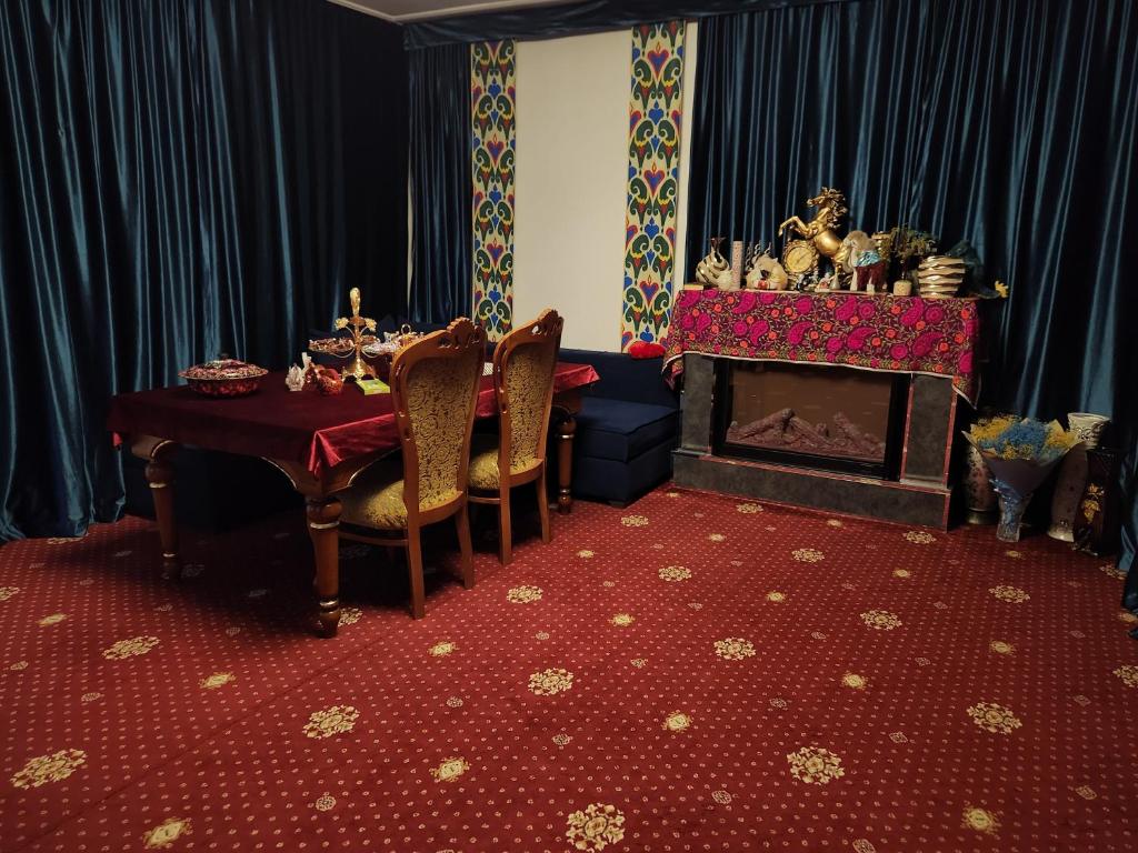 une salle à manger avec une table et une cheminée dans l'établissement Heyvah - Guest House in Tashkent, à Tachkent