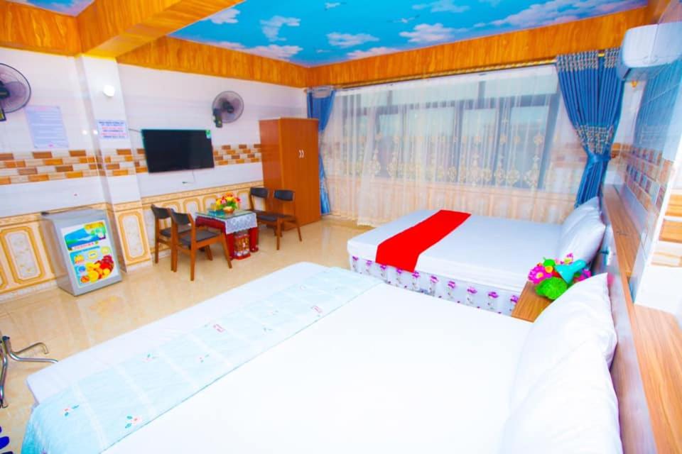 a bedroom with two beds and a table and a tv at Hưng Hà Hotel DB - by BAY LUXURY in Diện Biên Phủ