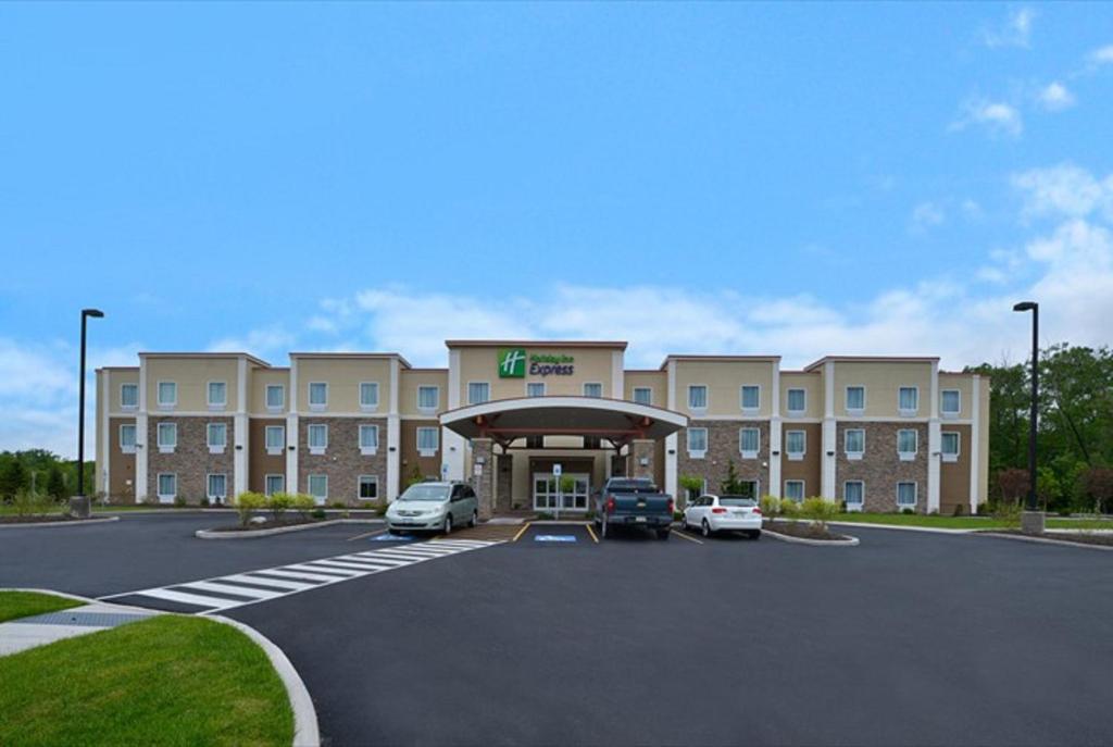 a hotel with cars parked in a parking lot at Holiday Inn Express Canandaigua, NY in Canandaigua