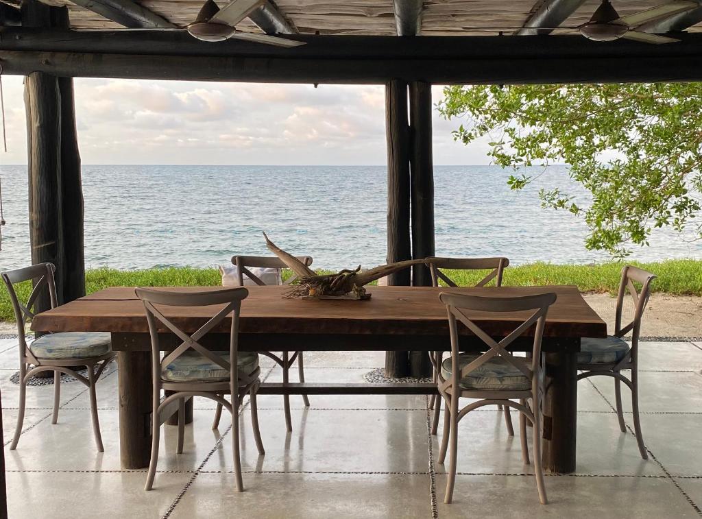 a wooden table and chairs with a view of the ocean at Sal Si Puedes in Tintipan Island