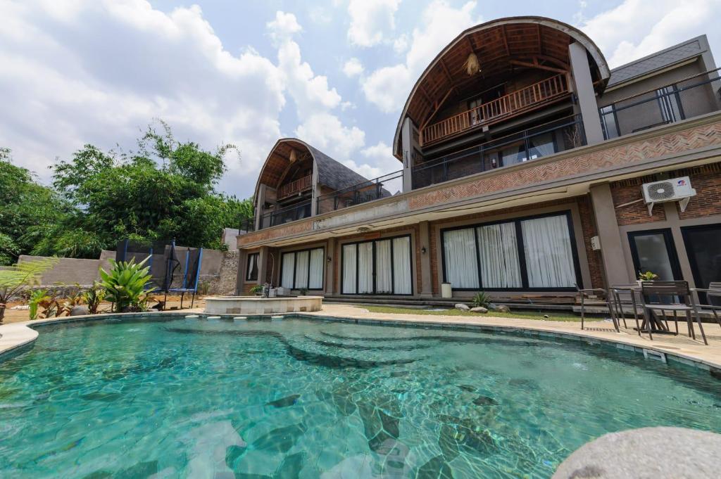 a large swimming pool in front of a building at Villa Sasandu Termanu in Gadog