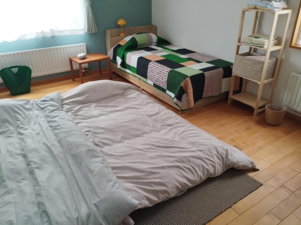 a bed sitting in a room with a bedskirts at Casa YuriMomo in Date