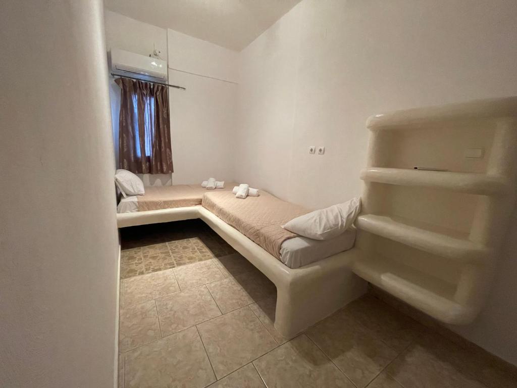 a bedroom with two beds and a window at Alice Maisonette & Studios in Adamas