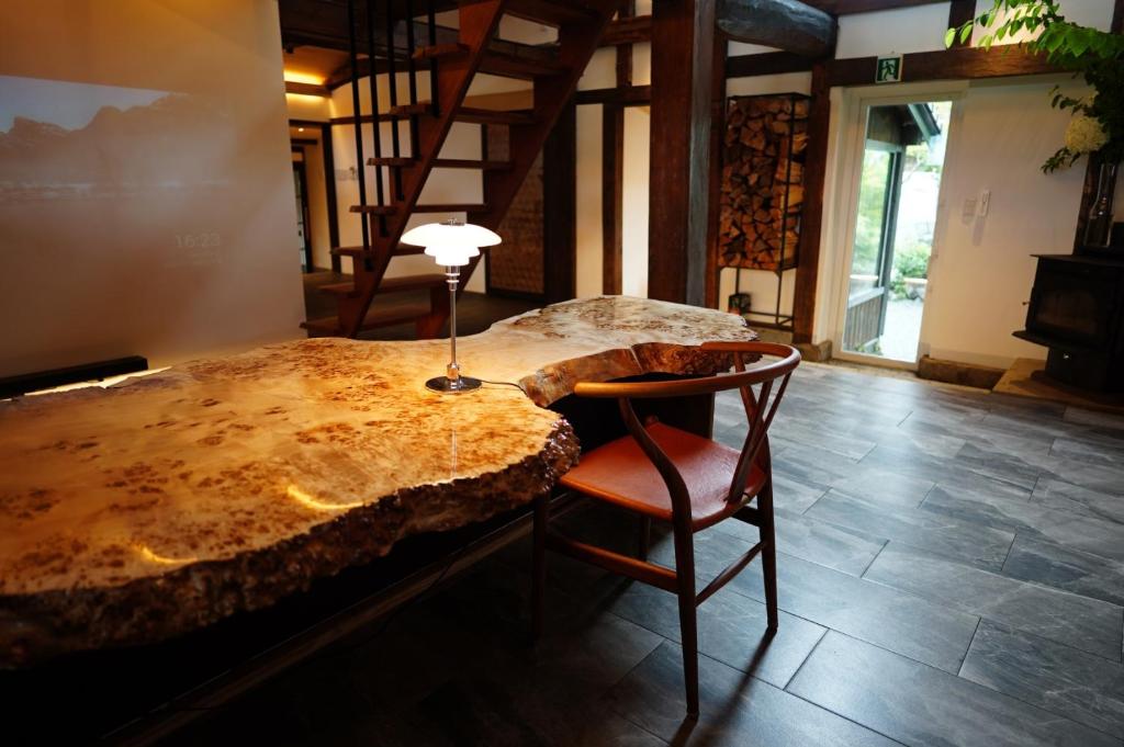 a bedroom with a bed and a table and a chair at 寝室から一望できる阿蘇山の絶景!!築200年の歴史ある米蔵をリノベーションした一棟貸しの宿 in Bōchū