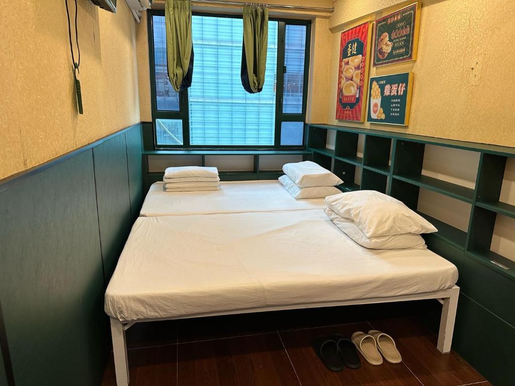 A bed or beds in a room at Just Inn on Nathan Road