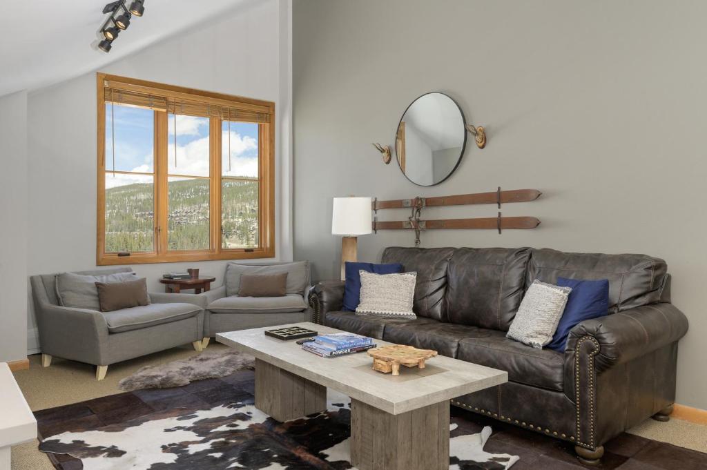 een woonkamer met een leren bank en een tafel bij Select Unit 1709 - 2BR - Zephyr Mountain Lodge condo in Winter Park