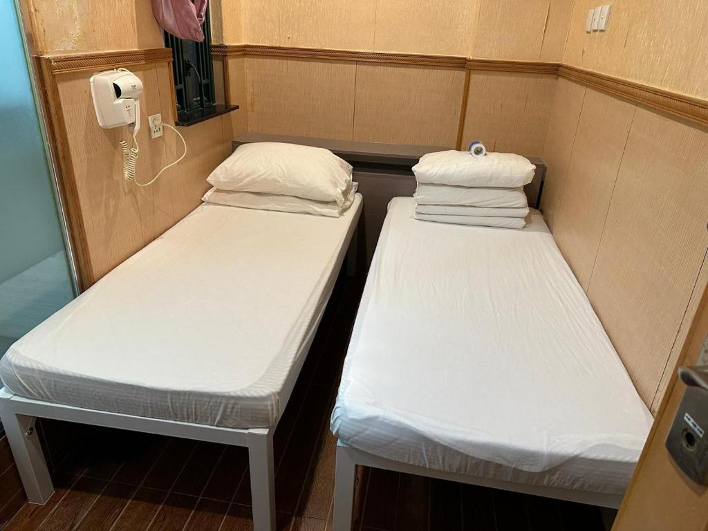 A bed or beds in a room at Just Inn on Nathan Road