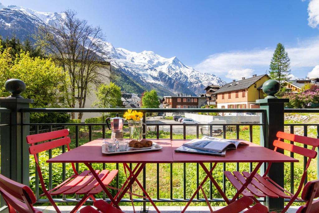 uma mesa e cadeiras numa varanda com montanhas em Appartement Belle Vue - Happy Rentals em Chamonix-Mont-Blanc