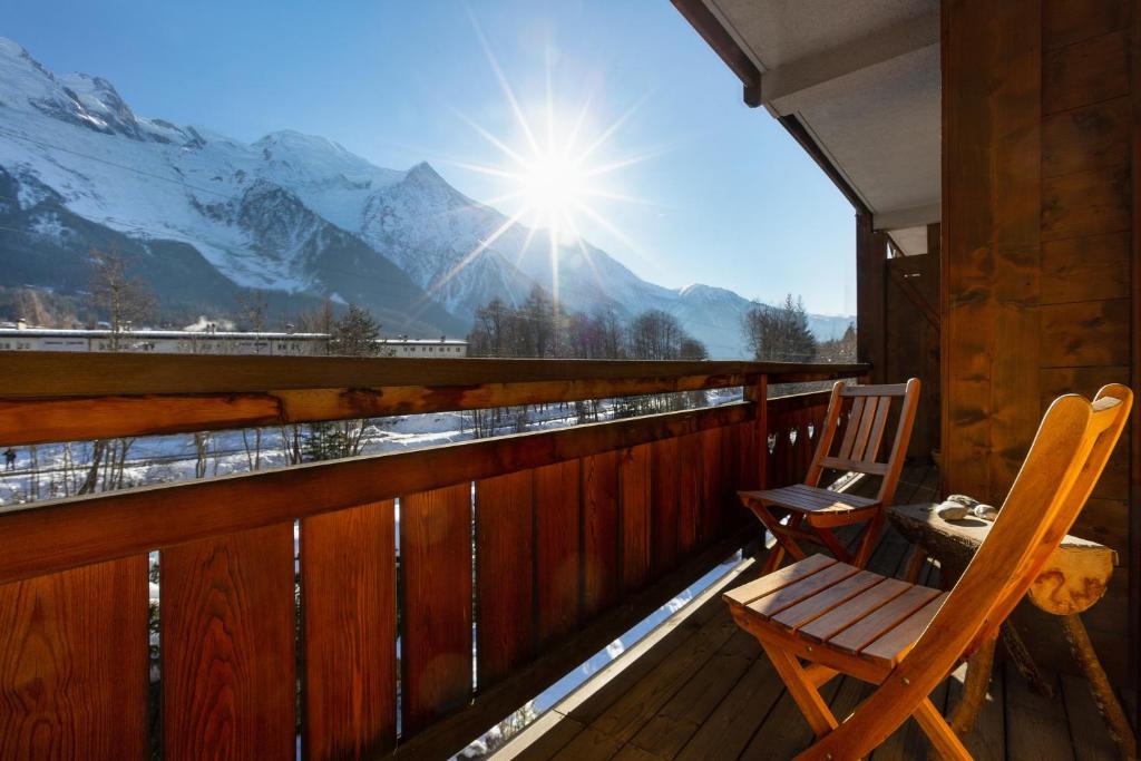 d'un fauteuil à bascule sur un balcon avec vue sur les montagnes. dans l'établissement Appartement Les Capucins 22 - Happy Rentals, à Chamonix-Mont-Blanc
