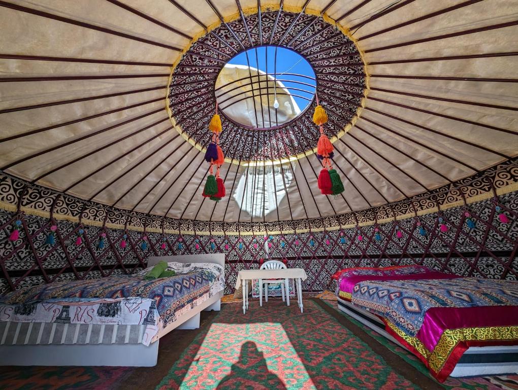 a yurt room with two beds and a mirror at Barskoon Guest House in Barskoon