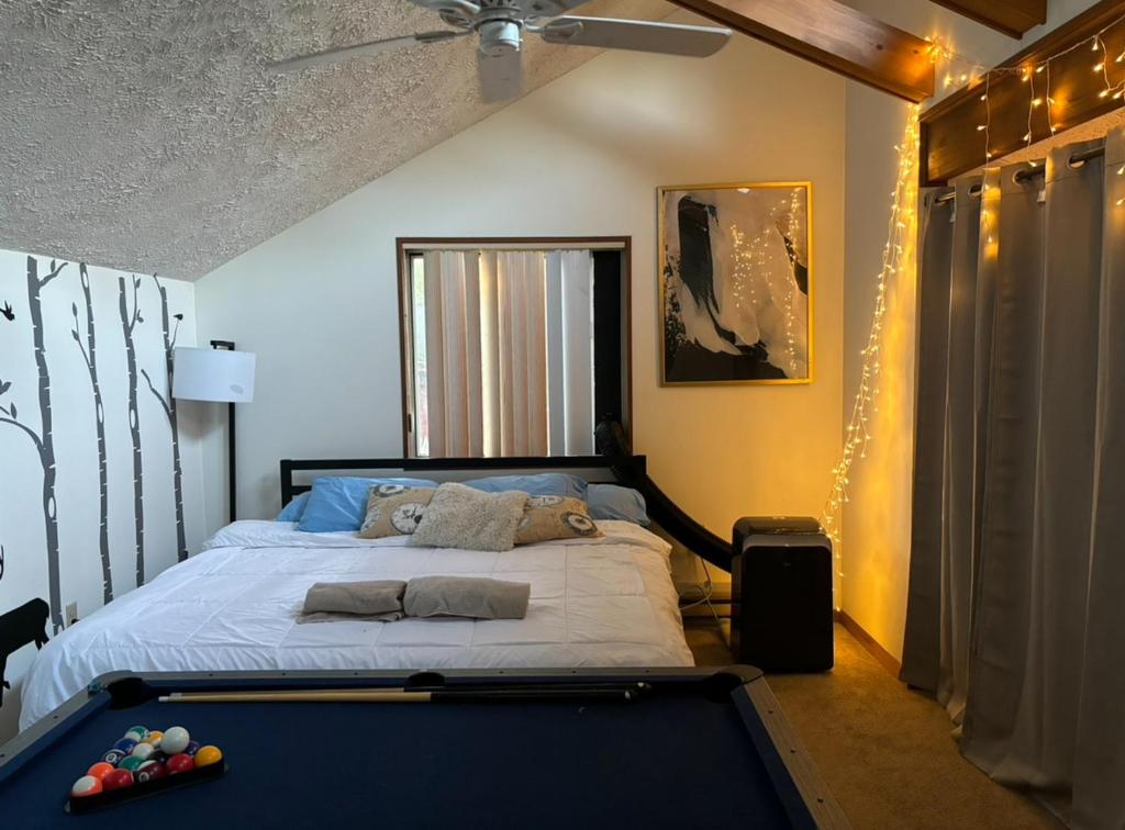 a bedroom with a bed with a pool table at Ambiance - KING BED Cabin Loft & Fireplace in Tobyhanna