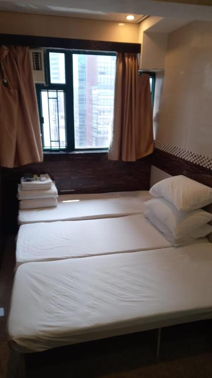 A bed or beds in a room at Hop Inn on Nathan Road
