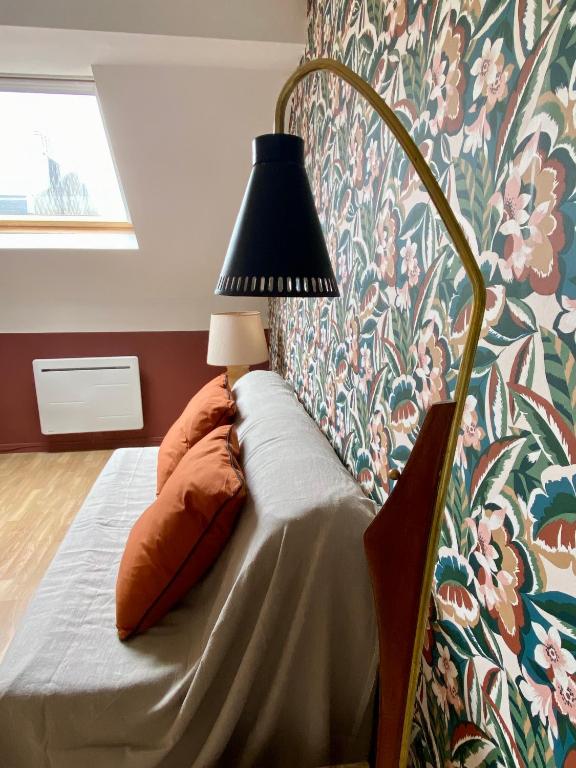 - une chambre avec un lit et une lampe dans l'établissement Les Mouettes de Wimereux, à Wimereux