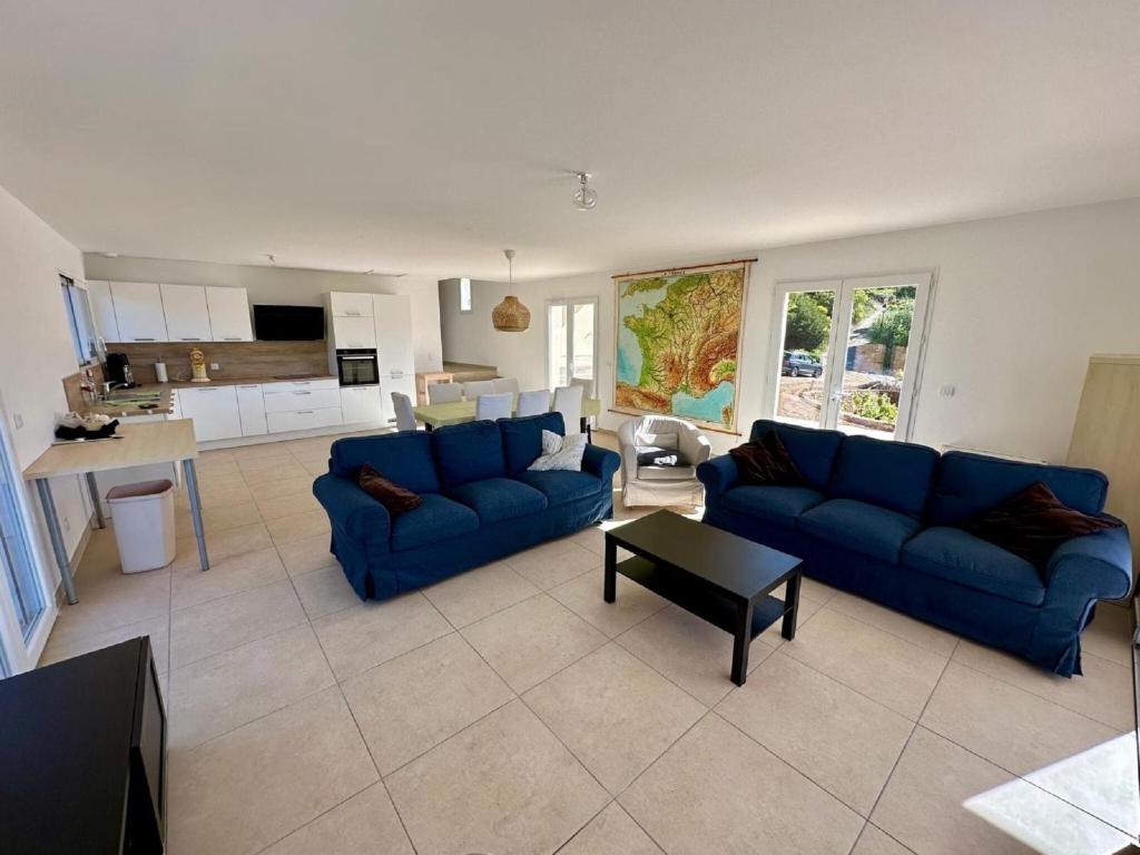 een woonkamer met twee blauwe banken en een tafel bij Villa l'Esquirol with view and pool in Roquebrun