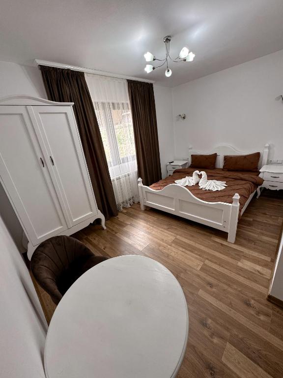a bedroom with a bed and a table in it at Casa Croitoru Maramureş in Onceşti