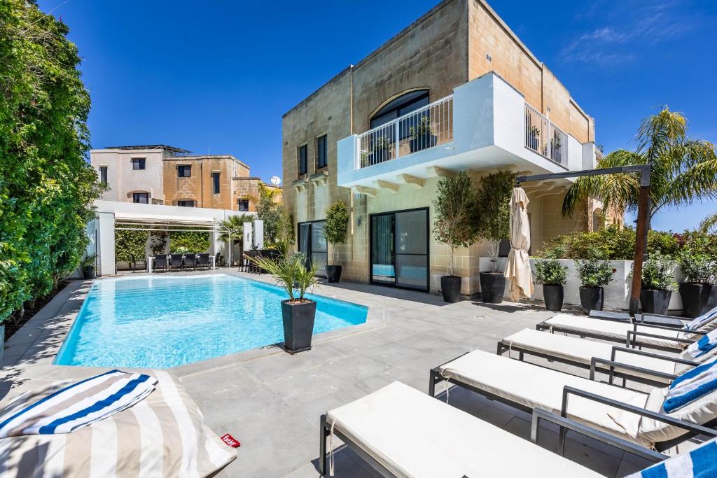 an exterior view of a house with a swimming pool at Luxurious Villa 5 BR, Pool, 3min from St Julian's in Is-Swieqi