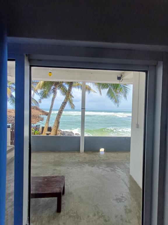 a door to a room with a view of the ocean at SEASHORE Resort & Villa in Talpe