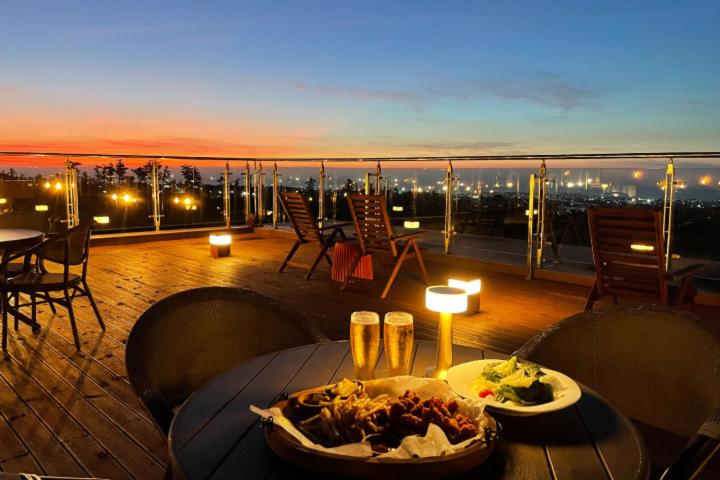 une table avec une assiette de nourriture sur un balcon dans l'établissement Camphortree Hotel and Resort, à Jeju