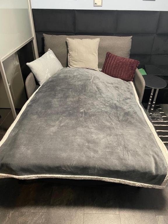 a large gray bed with two pillows on it at Ingress in Bytom