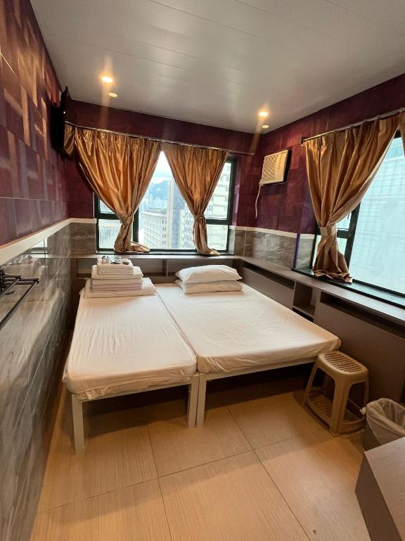 una camera con due letti e finestre di 3D Inn Hong Kong Romance a Hong Kong