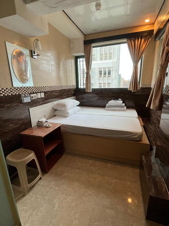 una camera da letto con un letto grande e una finestra di 3D Inn Hong Kong Romance a Hong Kong