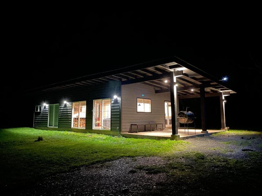 una casa iluminada por la noche con luces en Cabaña Azul en Riñinahue