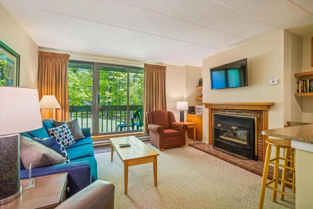 a living room with a blue couch and a fireplace at Pinnacle B04 in Killington